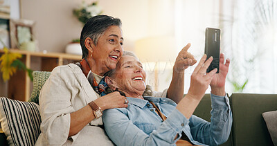 Buy stock photo Phone, mature and lesbian couple in house with conversation, social media video and bonding together. Happy, lgbt people and point on sofa with tech, relationship and discussion for online blog post.