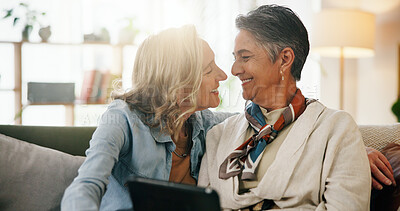 Buy stock photo Tablet, mature and lesbian couple in home with smile, connection and bonding together on weekend. Happy, lgbt people and relax in living room with digital tech, healthy relationship or love in house.