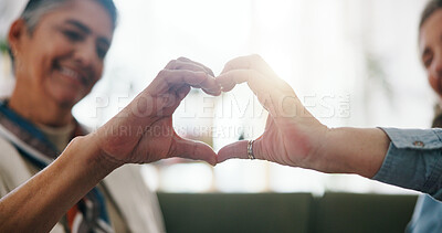 Buy stock photo Mature, women and heart hands with love in home for LGBTQ, pride or support together. Female people, gay couple or shape with romantic gesture, icon or lens flare for romance, care or trust in house