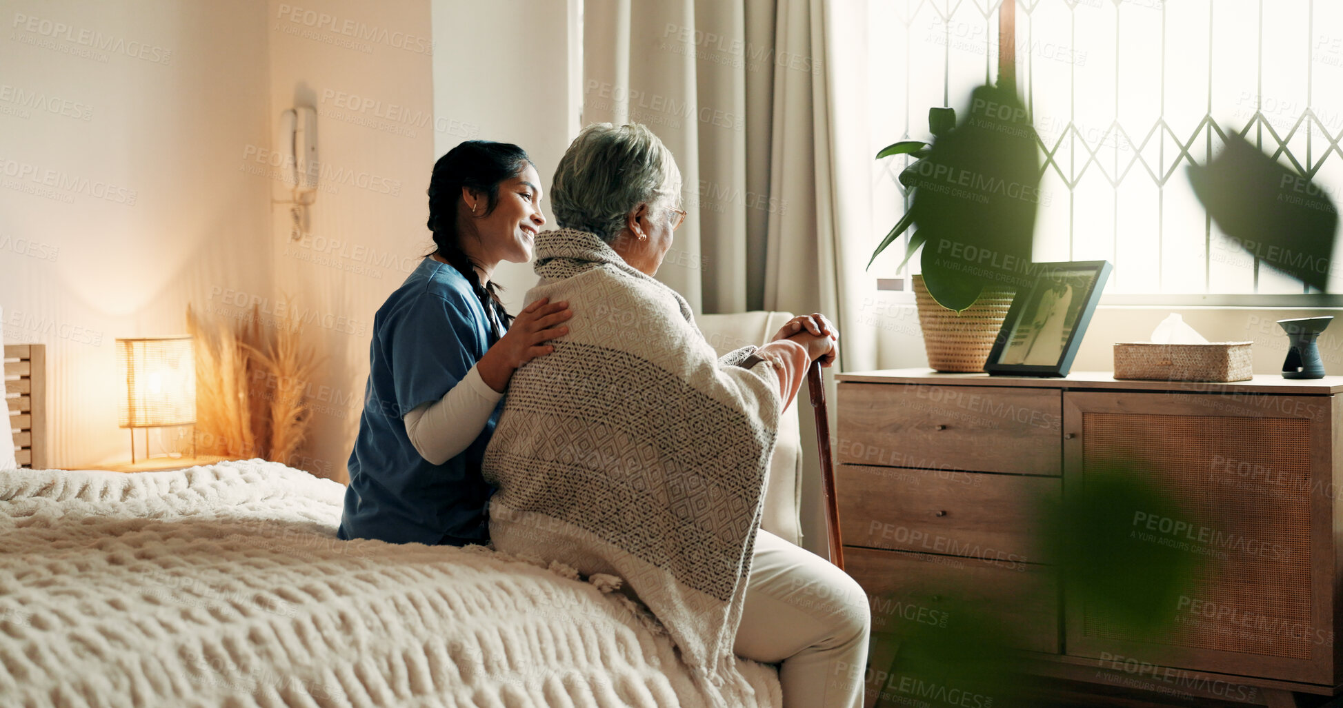 Buy stock photo Caregiver, support and old woman in nursing home with walking stick, relax and bonding together on bed. Nurse, help and elderly person with disability, cane and rehabilitation in retirement center.
