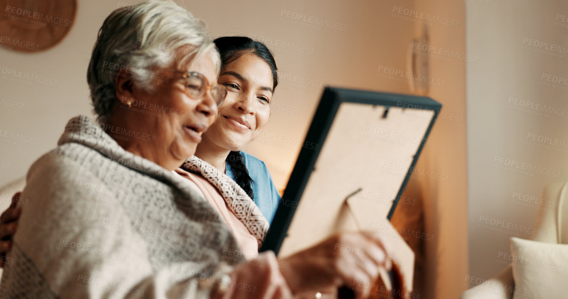 Buy stock photo Caregiver, talk and old woman in nursing home with picture frame, bonding and explain good memories. Happy, senior person and nurse in retirement center with photo, discussion and nostalgia for past.