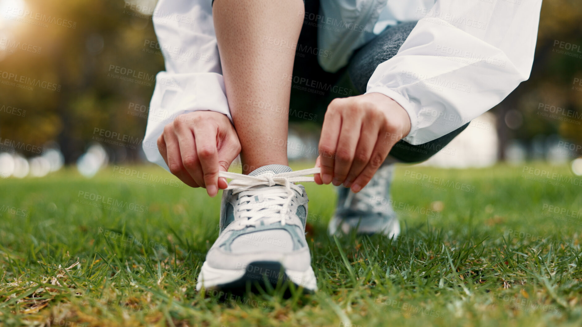 Buy stock photo Person, hands and tying with shoes on grass field for fitness, workout preparation or run in nature. Active, runner or getting ready with sneakers or laces for outdoor exercise or training in park
