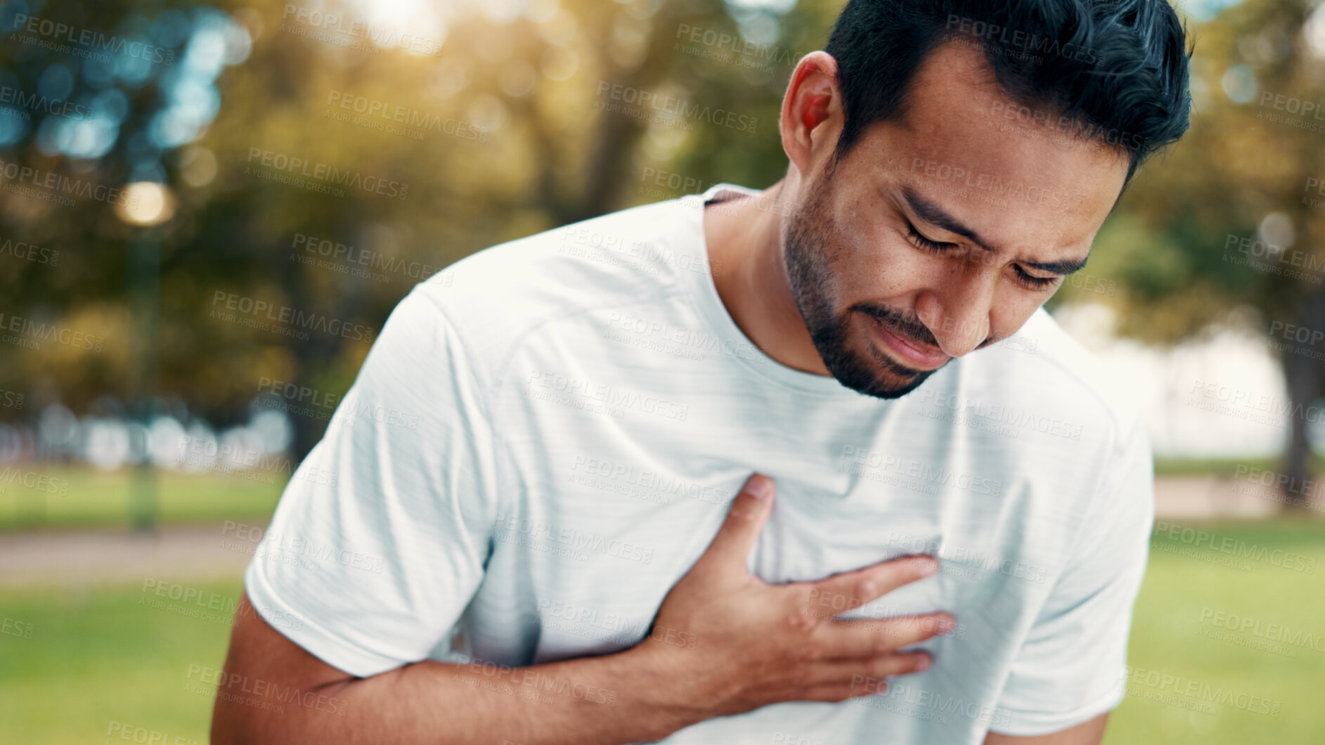 Buy stock photo Fitness, man and exhausted in park with chest pain, respiratory problem or hurt from intense exercise. Active, person and breathing issue outdoor with fatigue, sports injury or heart attack symptoms.