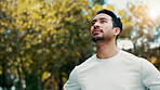 Athlete, man and thinking of fitness at park, serious and rest after workout or training in morning. Outdoor, runner and person in nature post exercise, space and cool down on break and low angle