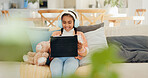 Education, headphones and tablet with girl child on living room sofa for interactive learning. App, smile and streaming with happy kid in home for online course, remote study or virtual lesson