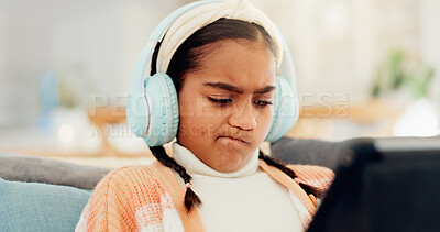 Buy stock photo Confused, headphones and tablet with girl student on living room sofa for interactive learning. App, streaming and thinking with child in home for online course, remote study or virtual lesson