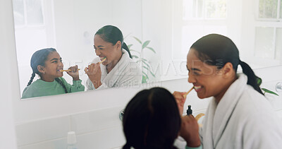 Buy stock photo Mom, girl and brushing teeth in bathroom for dental hygiene, grooming or cleaning together. Mother, child or daughter with smile, mirror or reflection for mouth, oral care or morning routine in home