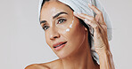 Skincare, thinking and woman with lotion in studio, apply retinol moisturizer and anti aging treatment. Beauty, reflection and mature person with cream for hydration, glowing skin or white background