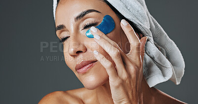 Buy stock photo Eye patch, woman and skincare in studio for anti aging, confidence and aesthetic in dermatology. Mature person, treatment and towel with cosmetology, beauty or cosmetics with glow on gray background