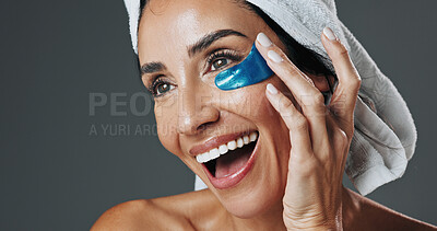 Buy stock photo Happy woman, studio and skincare with eye patch for collagen or detox on a gray background. Female person, model or smile with mask or facial treatment for beauty cosmetics, anti aging or hydration