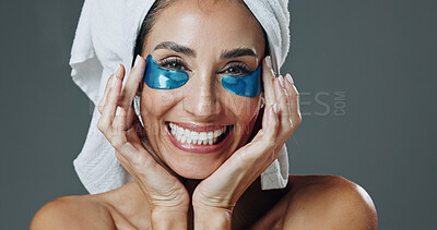 Buy stock photo Skincare, portrait or woman with eye mask in studio, dark circles reduction or anti aging treatment. Beauty, smile or mature person with collagen patches for hydration, self care or gray background