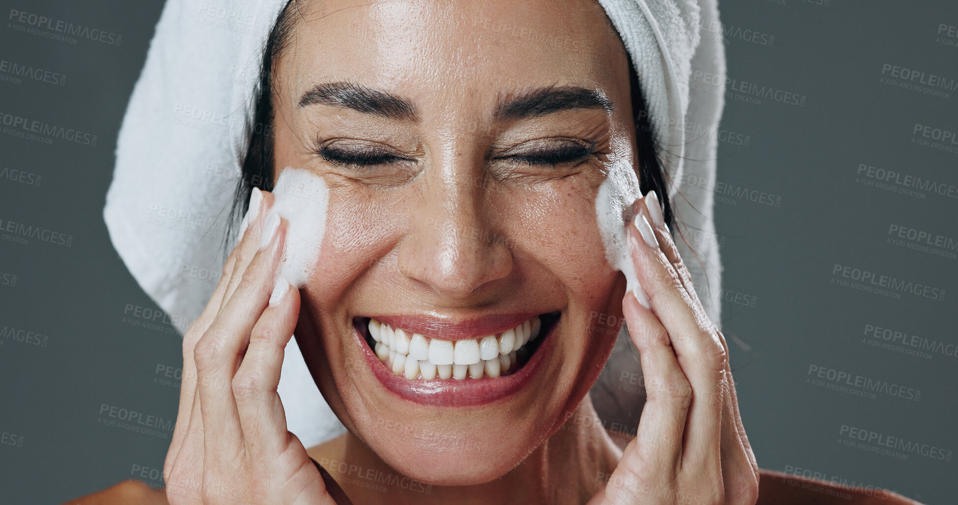 Buy stock photo Skincare, face wash and woman with smile in studio, morning routine and grooming for natural beauty. Cleaning skin, facial cleanser and mature person with soap for wellness, happy and gray background