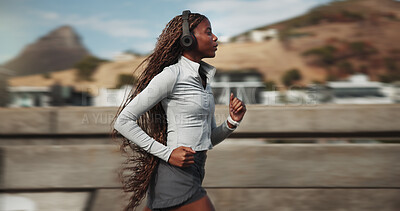 Buy stock photo Fitness, woman and running with headphones in city for speed challenge, cardio and interval training. Fast athlete, black person and sprint on bridge for exercise, sport performance and workout music