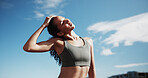 Fitness, city and woman stretching neck for exercise, training and warm up for workout with blue sky. Sports, runner and person getting ready for wellness, health or mobility for active hobby in town