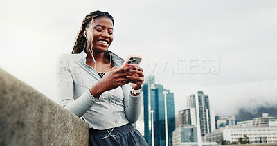 Buy stock photo Fitness, earphones and happy woman with smartphone on bridge, laughing or listening to music on web. City, space and black person with mobile for funny chat, low angle and audio on exercise break