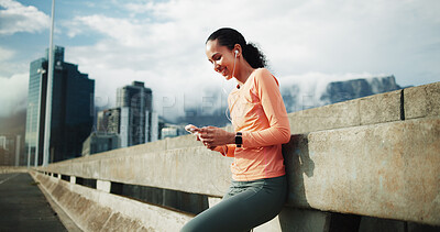 Buy stock photo Bridge, earphones and happy woman with smartphone after workout, scroll or listening to music on web. City, athlete and person with mobile for message, fitness and streaming audio on exercise break