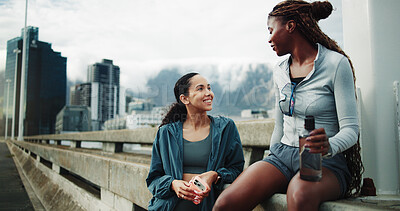 Buy stock photo Women, friends and smile for fitness, rest and communication for outdoor training on street. City bridge, chat and people with exercise break for health, workout or marathon practice together