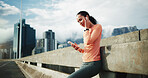 City, earphones and woman with smartphone after workout, streaming and listening to music on website. Outdoor, athlete and person with mobile for message, fitness or audio on exercise break on bridge