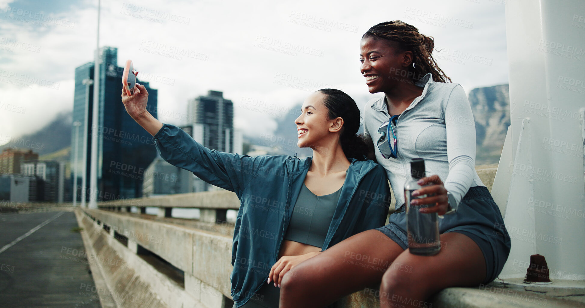 Buy stock photo Exercise, friends and women in city for selfie, cardio workout or social media post on bridge. People, overcast or runners training for wellness, sports and urban photography outdoor with a smile
