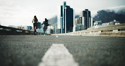Buy stock photo Woman, back and running in city for fitness with low angle, ground or asphalt for outdoor workout. People, friends and exercise for cardio challenge in winter, training and sprint on road in town