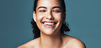 Portrait, skincare and beauty with funny woman, glow and shine with dermatology on blue background. Cosmetics, laugh and person with aesthetic in studio, natural skin and wellness with self care