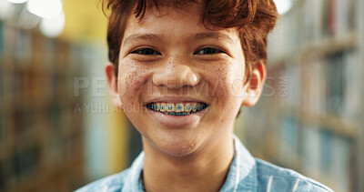 Buy stock photo Portrait, education and boy in library, happiness and knowledge for child development. Student, braces and kid in school, laughing and study for scholarship, books and information literacy for growth