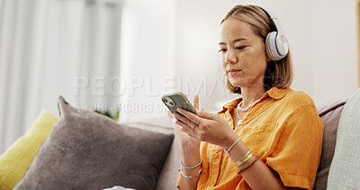 Buy stock photo Chill, phone or Asian woman in home with headphones, song connection or listening to music playlist. Relax, scroll or person in living room with tech, podcast or radio subscription on audio app.