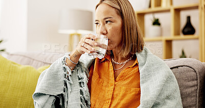 Buy stock photo Water, relax and woman on sofa in home with blanket for hydration, health or wellness. Thirsty, detox and female person drinking liquid for gut support or nutrition in living room at apartment.