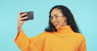 Buy stock photo Happy, glasses and woman in studio with selfie for social media, online post and content creator. Phone, influencer and person with smile for profile picture, photo and memory on blue background