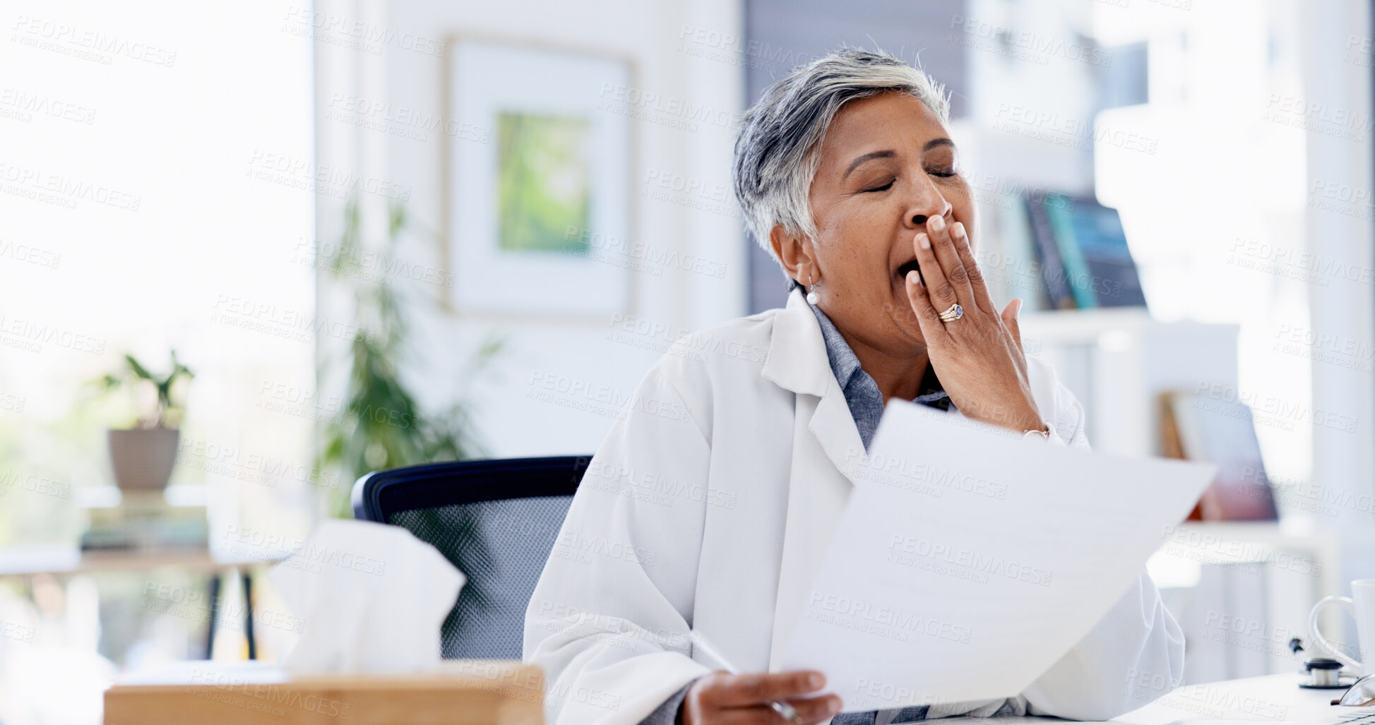Buy stock photo Doctor, paperwork and woman with yawn at office for admin, fatigue and exhausted with medical job. Mature person, tired and documents for healthcare report, review and feedback with burnout at clinic