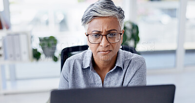 Buy stock photo Serious, online and businesswoman with laptop in office, research and financial analysis on website. Business, bookkeeper and mature person with tech for tax preparation, glasses and reading on app