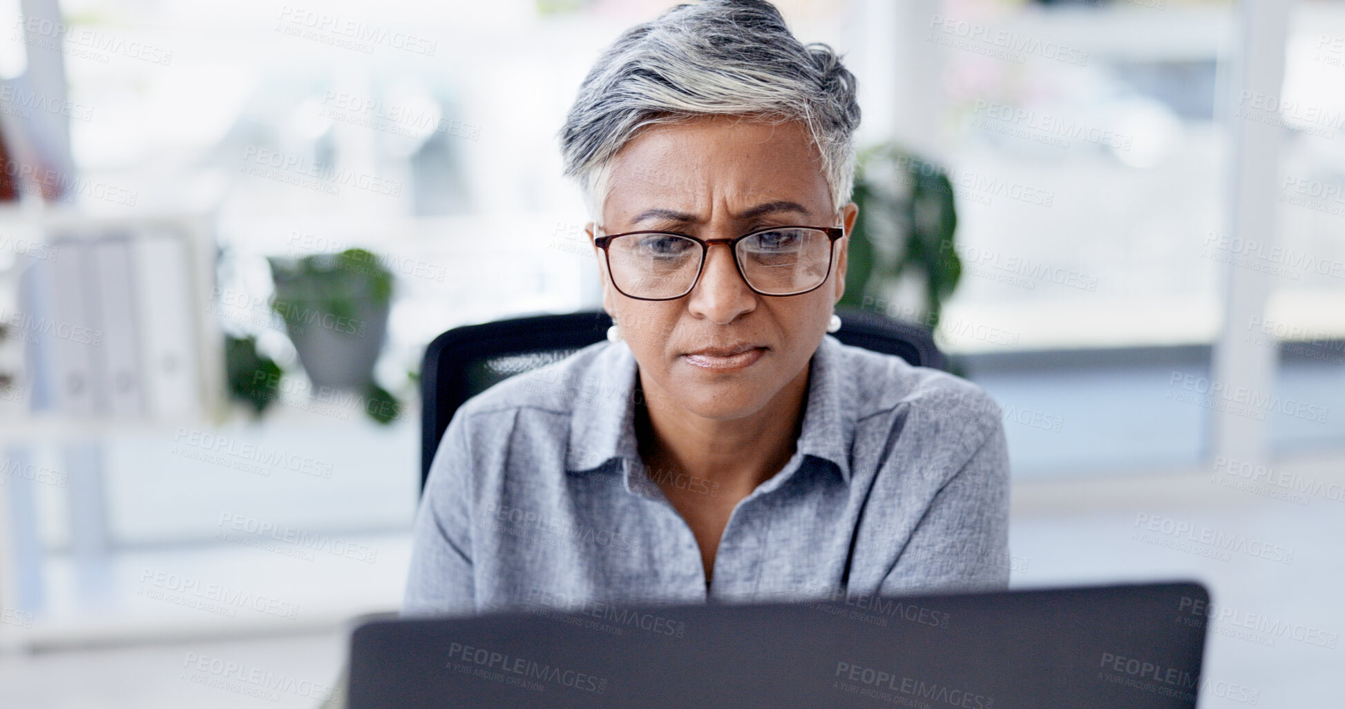 Buy stock photo Serious, online and businesswoman with laptop in office, research and financial analysis on website. Business, bookkeeper and mature person with tech for tax preparation, glasses and reading on app