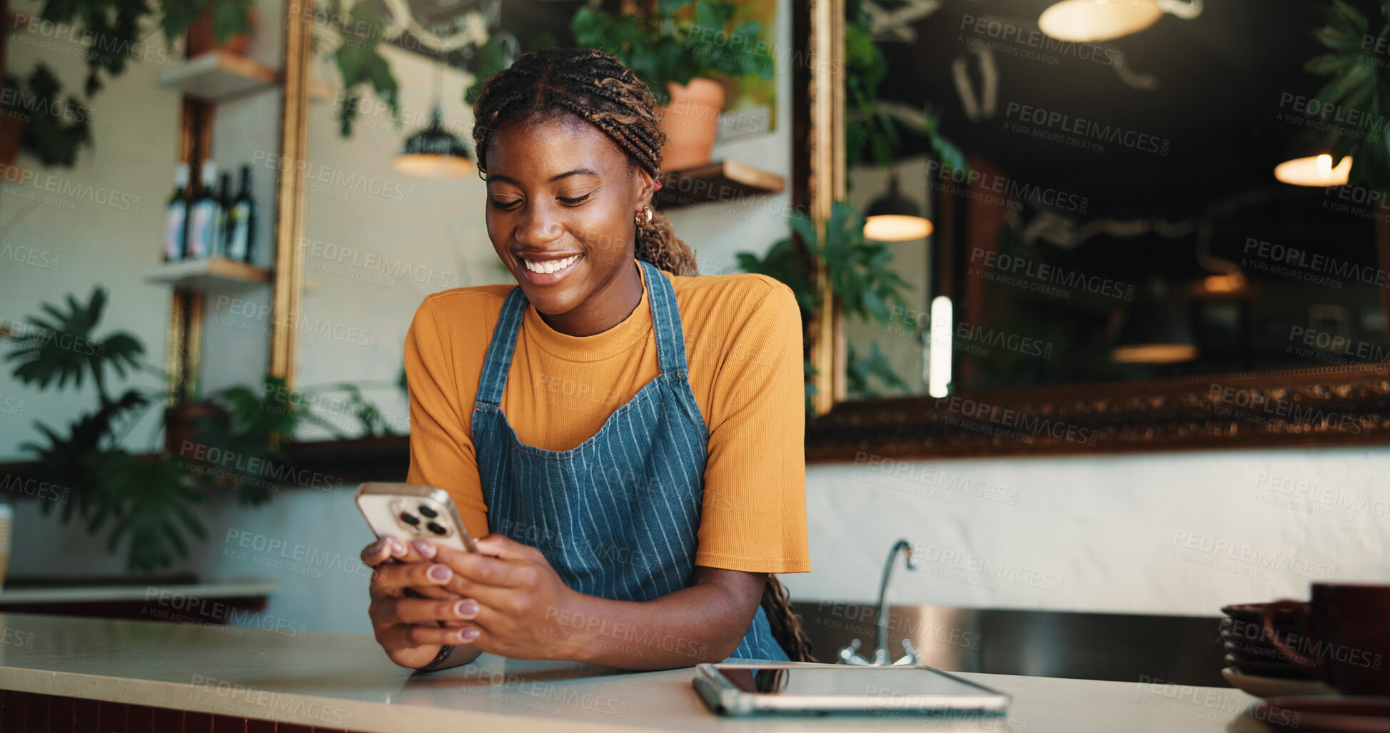 Buy stock photo Happy, waitress and black woman in cafe with phone, text message and notification for online order. Person, smile and browsing in restaurant with tech, social media post or mobile app for hospitality