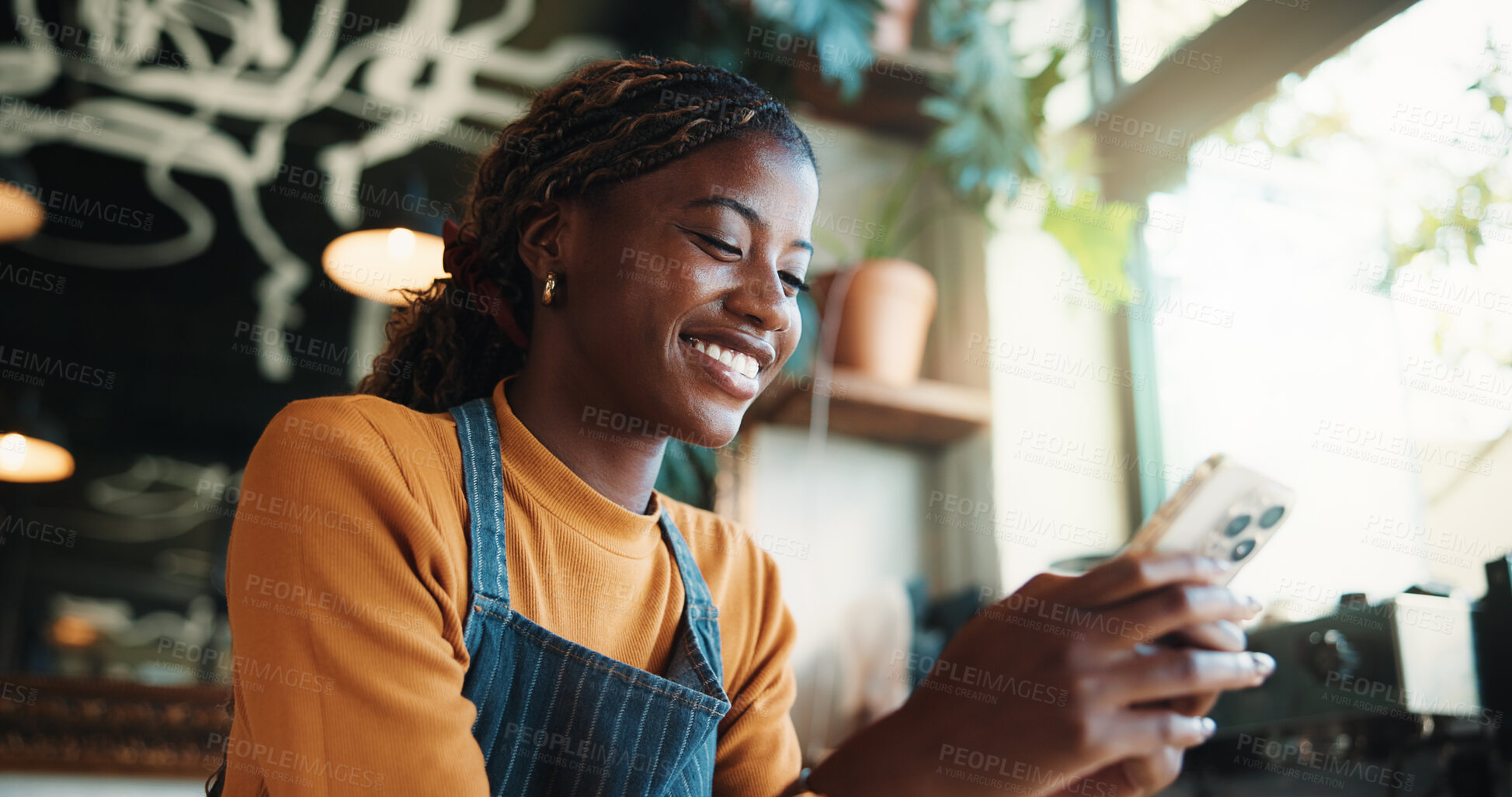 Buy stock photo Waitress, woman and text message in cafe with phone, smile and check notification for online order. Happy, black person and scroll in restaurant with tech, social media or mobile app for hospitality.