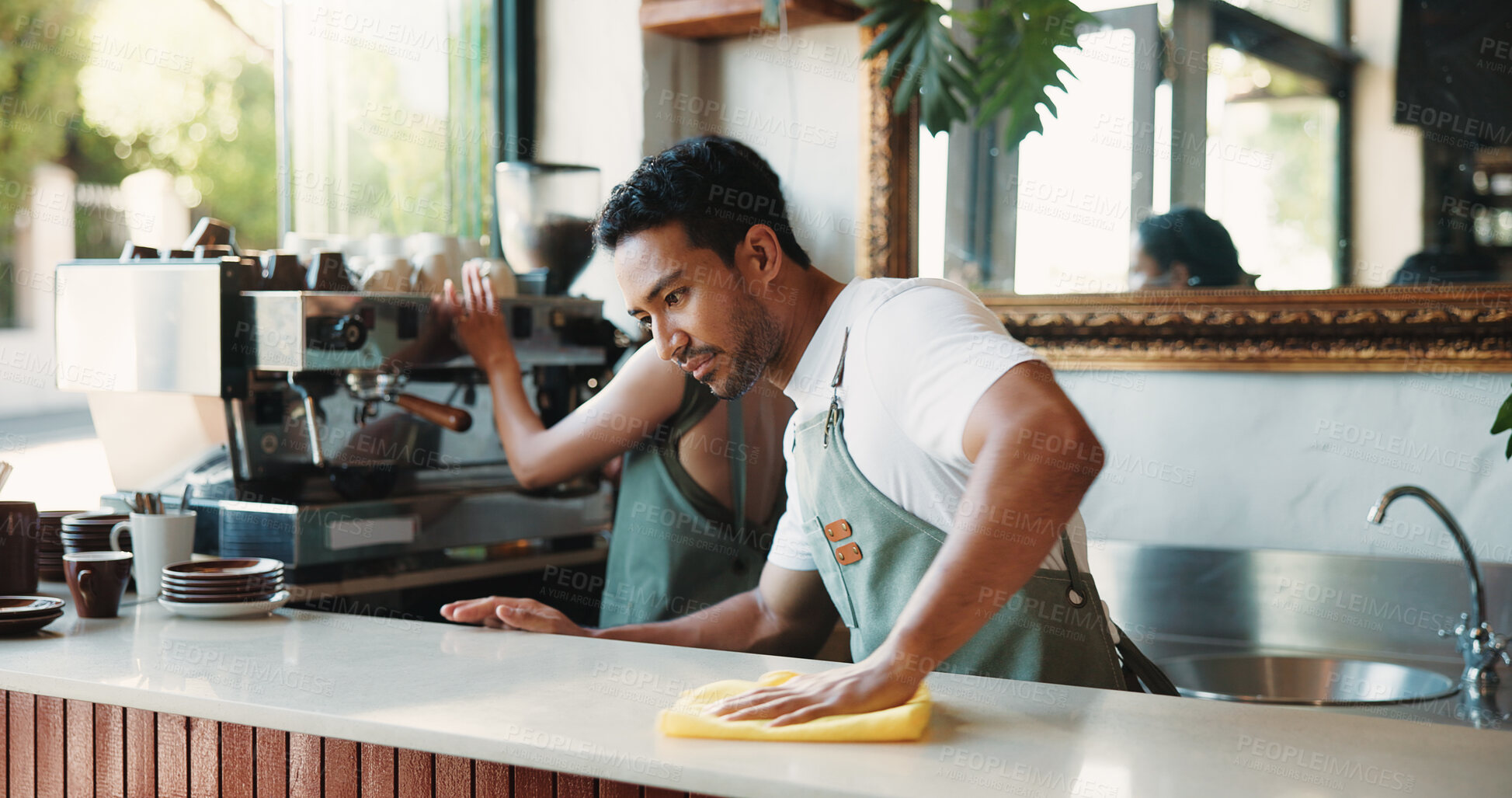 Buy stock photo Cleaning, cloth and counter with man in coffee shop for maintenance of small business startup. Hospitality, hygiene and wipe with people in restaurant cafe to disinfect surface for sanitizing routine