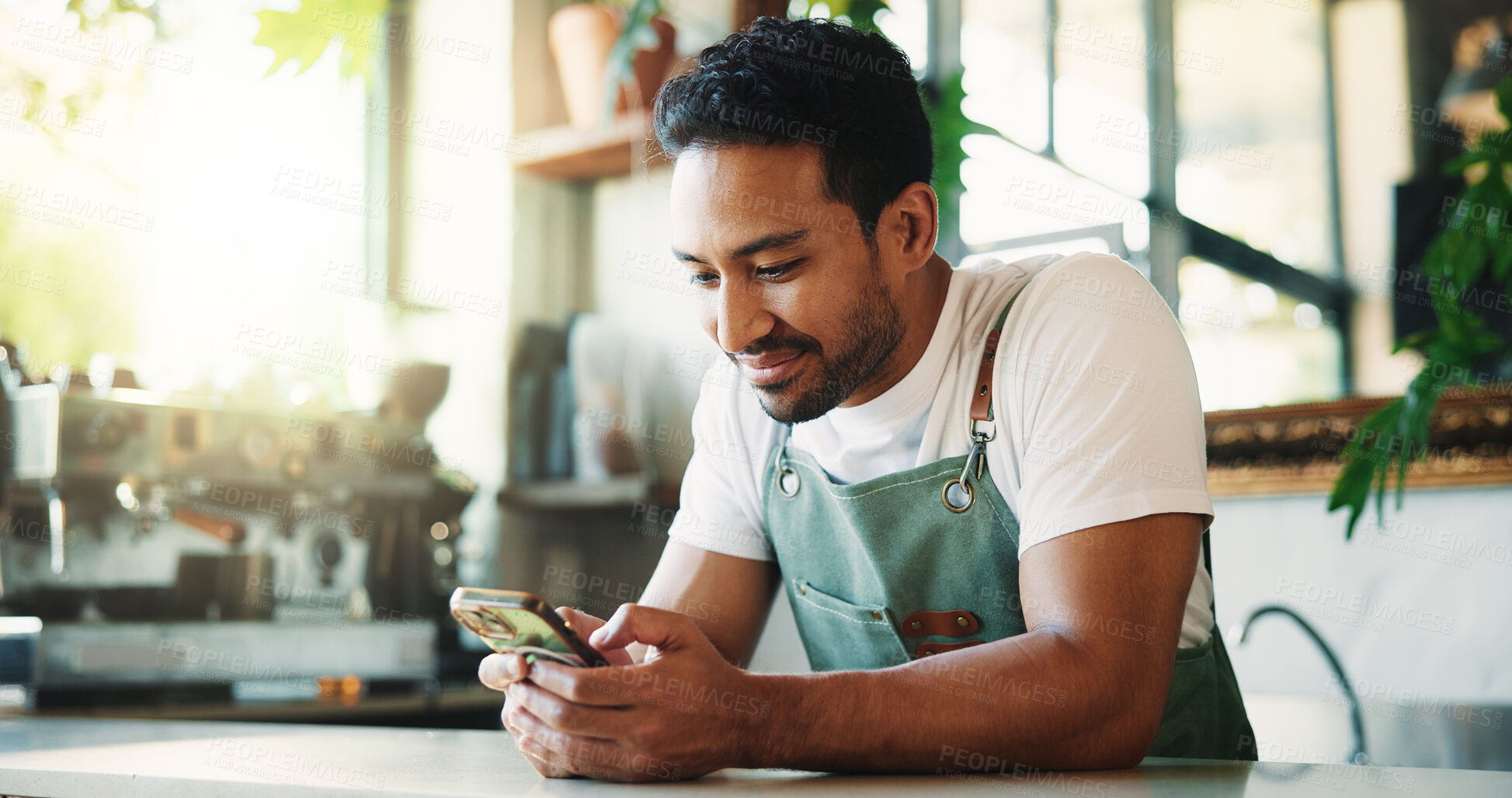 Buy stock photo Message, smile and barista in cafe with phone, chat or social media update on work break. Texting, happy or man in restaurant with tech, business review or online communication for networking.