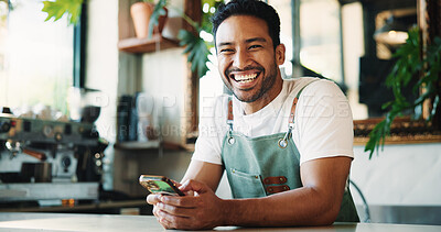 Buy stock photo Message, portrait and barista in cafe with phone, chat or social media comment on work break. Texting, happy or male person with tech, restaurant review or online communication for networking.