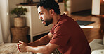 Sad, reflection and man with depression, anxiety or remember memories of sorrow alone in living room. Disappointed, thinking and person with mental health, stress or contemplation for regret in home.