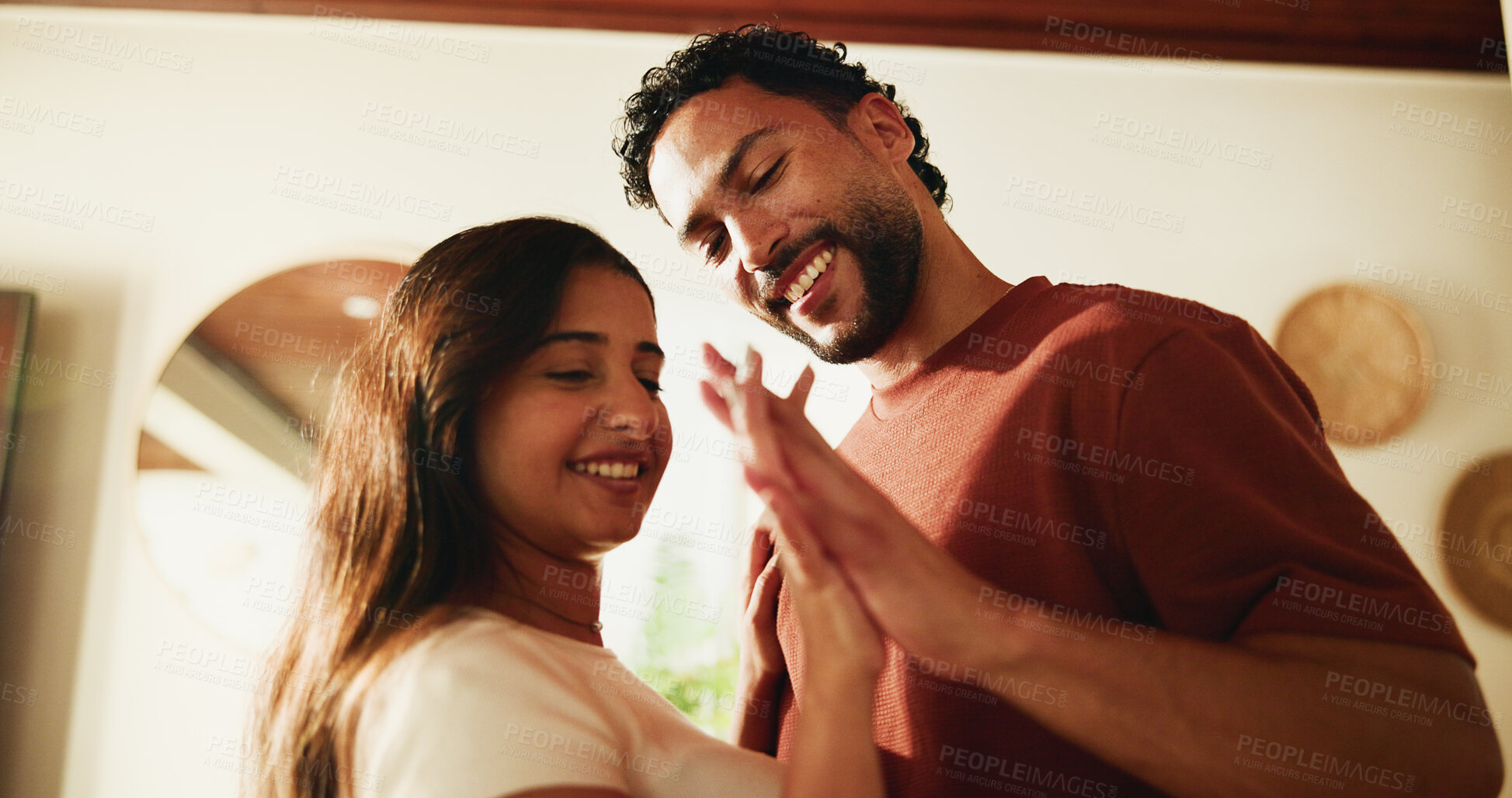 Buy stock photo Happy, couple and holding hands in home with love, romantic connection or bonding together on weekend. People, smile and affection in living room with marriage commitment, loyalty or care for partner
