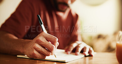 Buy stock photo Man, writing and hands with book in home for schedule, planning or calendar reminder. Male person, freelancer or remote work with diary or notebook for daily tasks, agenda or ideas on desk in house