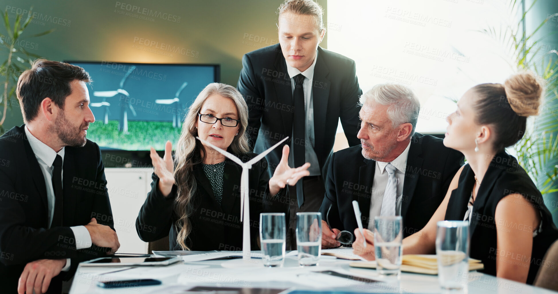 Buy stock photo Business, people and meeting with windmill in office for planning, discussion and renewable energy. Team, talking and pitch with wind turbine prototype, eco-friendly design and electricity innovation