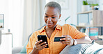 Happy, black woman and phone with credit card on sofa for online shopping or banking app in home. Female person, shopper or smile with debit or smartphone for mobile payment or wireless transaction