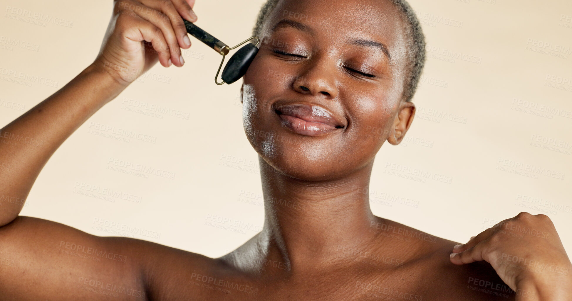 Buy stock photo Smile, black woman and skincare with roller in studio background for beauty, anti aging and shine. Happy, person and cosmetics for facial massage, lymphatic drainage and treatment for natural glow