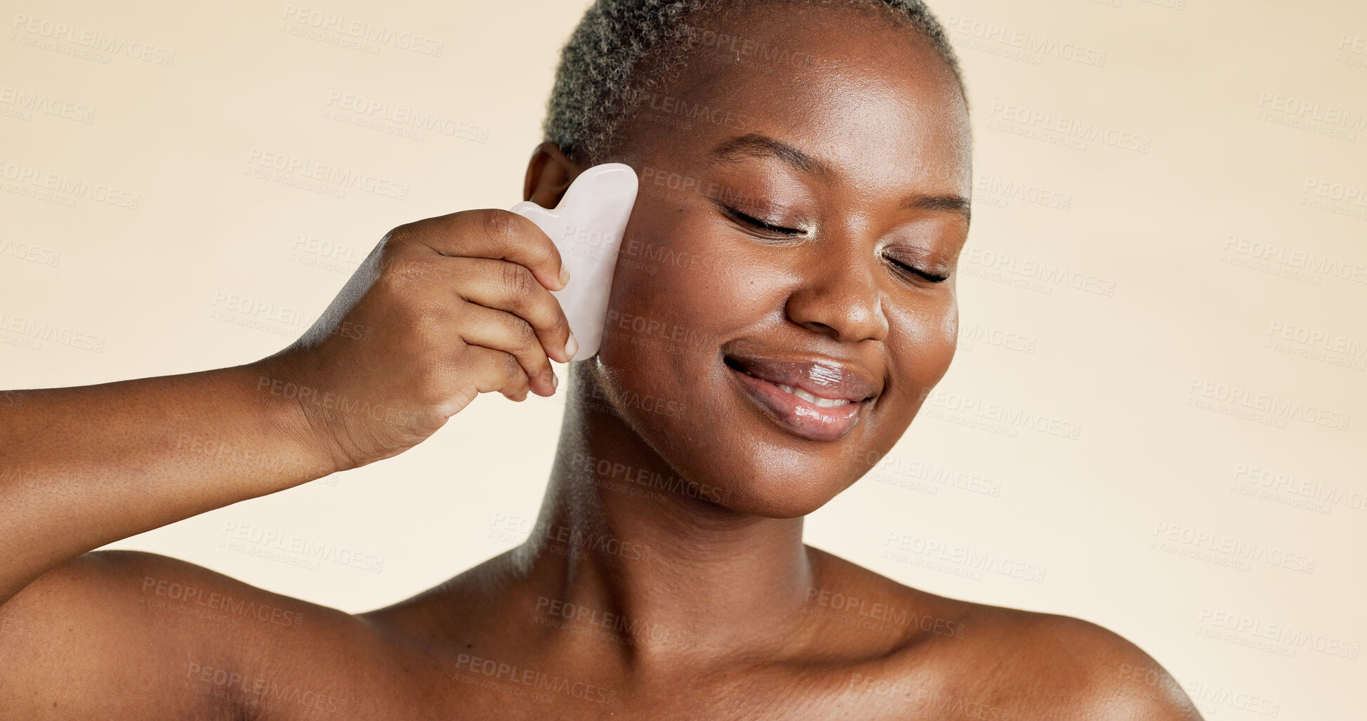 Buy stock photo Smile, black woman and skincare with gua sha in studio background for beauty, anti aging and shine. Happy, person and cosmetics for facial massage, lymphatic drainage and treatment for natural glow
