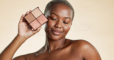Buy stock photo Makeup, palette and black woman with smile for foundation, highlighter and powder for beauty aesthetic. Happy, female person and cosmetic product for eyeshadow, glow and shine on studio background.