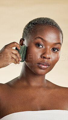 Buy stock photo Black woman, beauty and portrait with stone for self care, natural skincare and lymphatic drainage. Facial, glow and gua sha on studio background for wellness, dermatology and tool for radiance