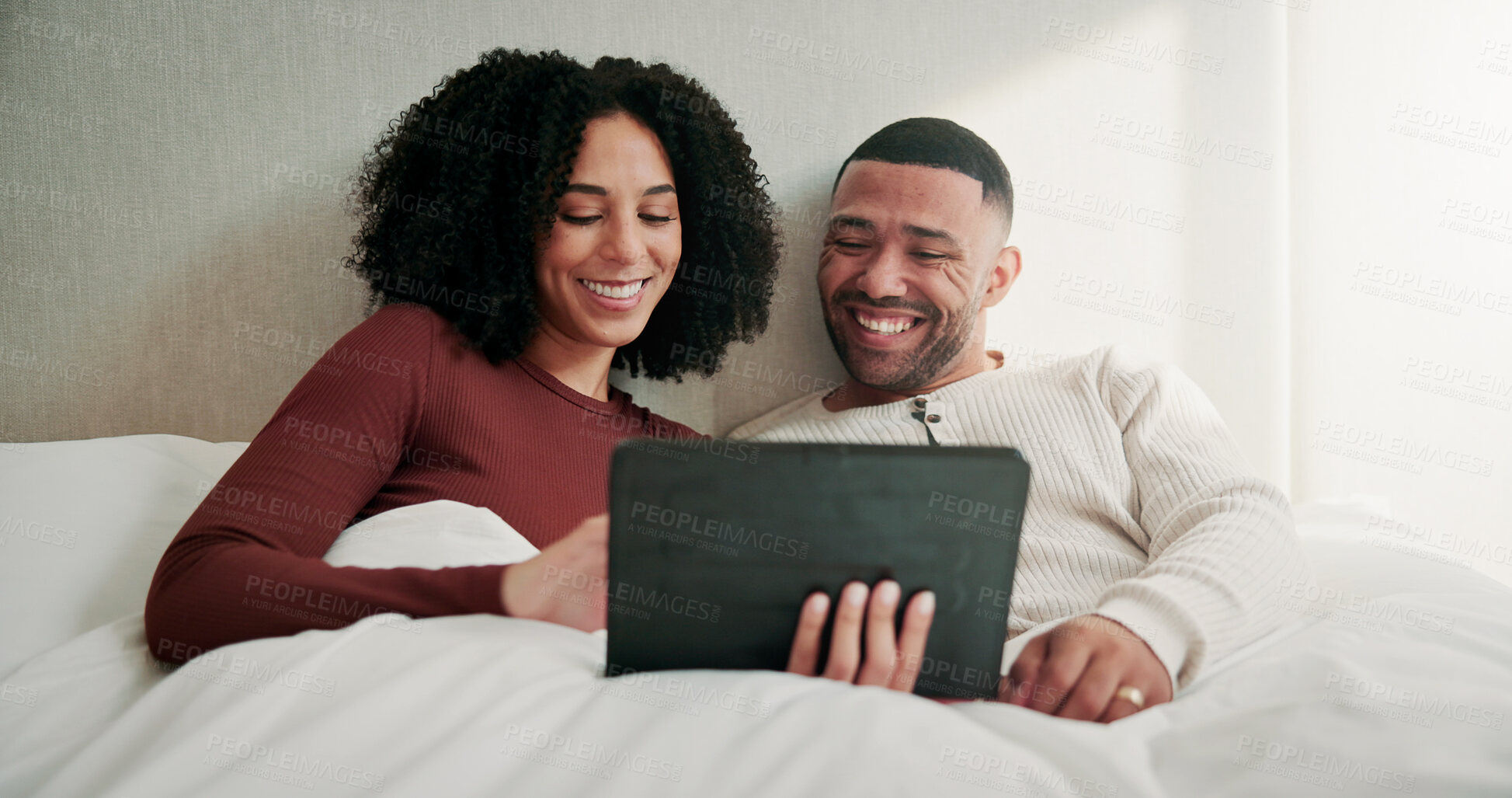 Buy stock photo Tablet, happy and couple on bed in home with watching comedy movie, series or show together. Smile, relax and man with woman in bedroom with digital technology for streaming film with subscription.