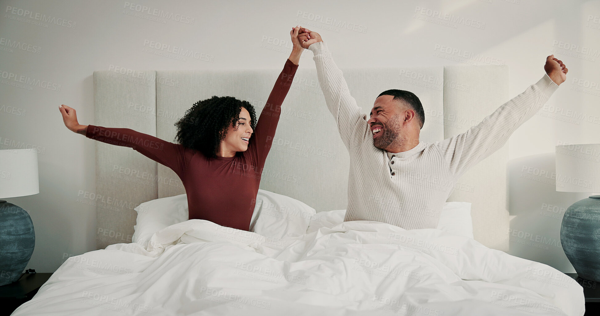 Buy stock photo Couple, stretching and holding hands in bed with smile from sleeping, wake up and weekend break. People, happiness and positive attitude for stress relief, comfortable nap and morning routine in home