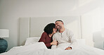Happy, couple and relax with love in bedroom from sleeping, romance and cosy weekend. Smile, people or laugh with romantic embrace for partner affection, comfortable break and morning routine in home