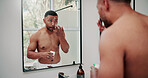 Man, skincare and mirror with face cream for hygiene, facial or anti aging treatment in home. Male person, lotion or moisturizer with reflection for beauty cosmetics or morning routine in house